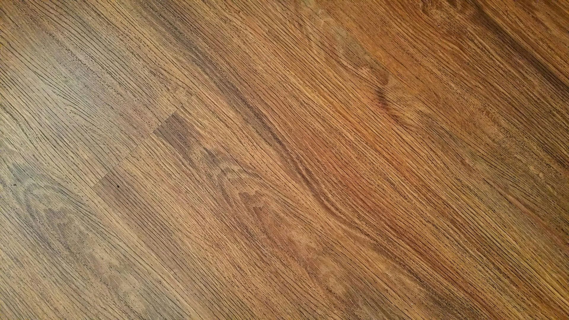 Un primer plano de un piso de madera con un patrón diagonal.