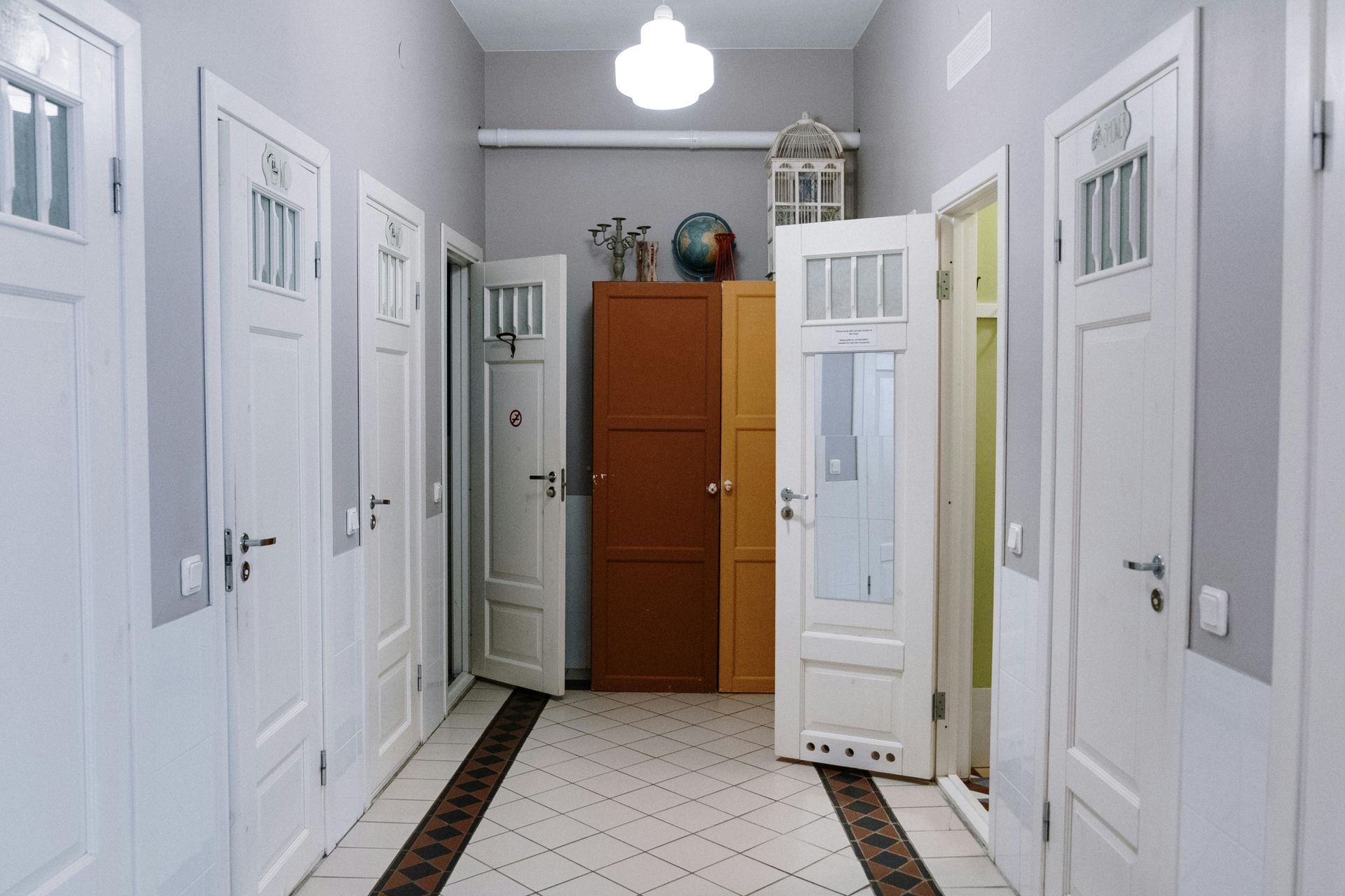 Un pasillo con muchas puertas y un globo terráqueo en la pared.