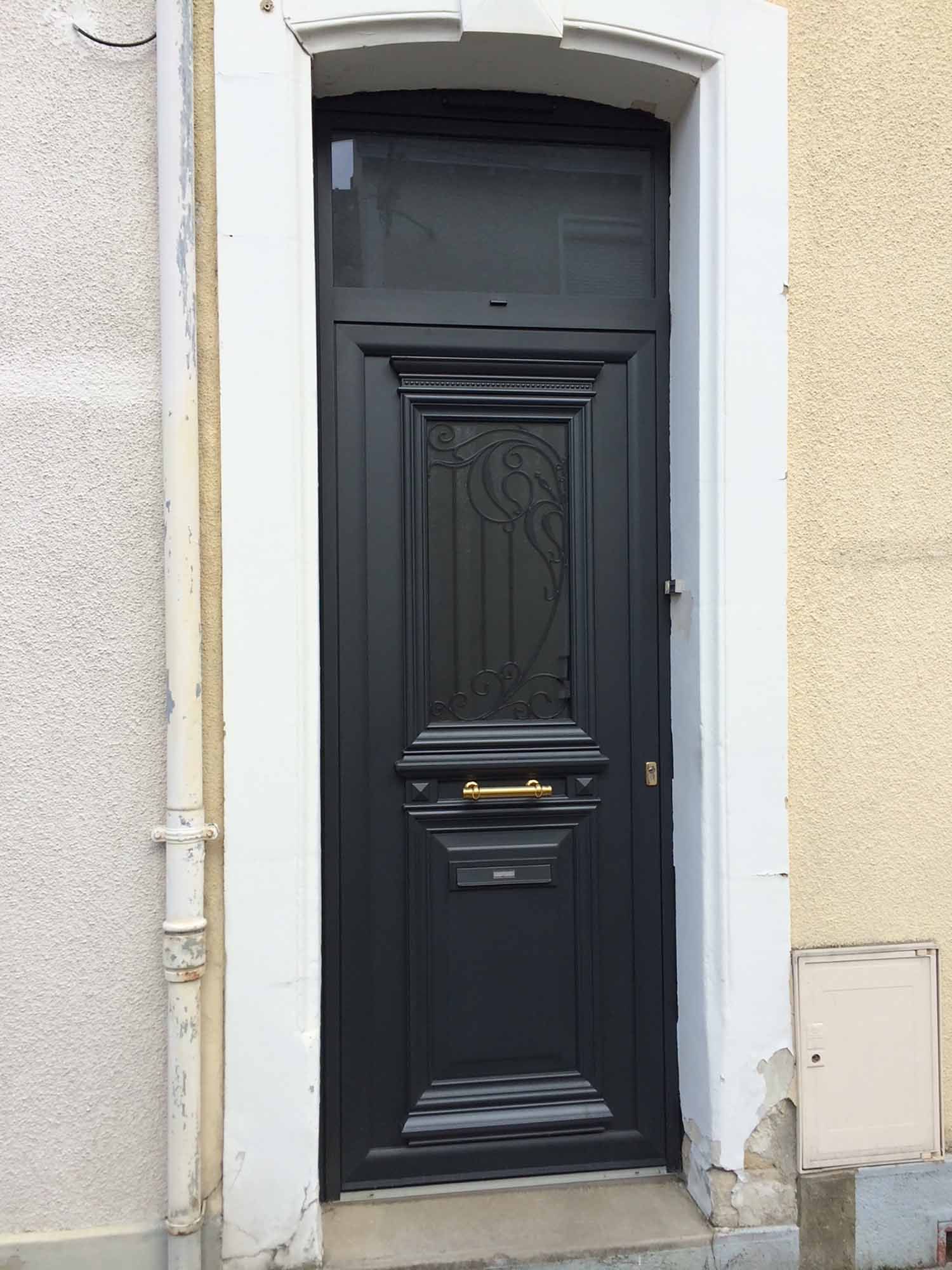 Une porte d'entrée noire avec une poignée couleur or