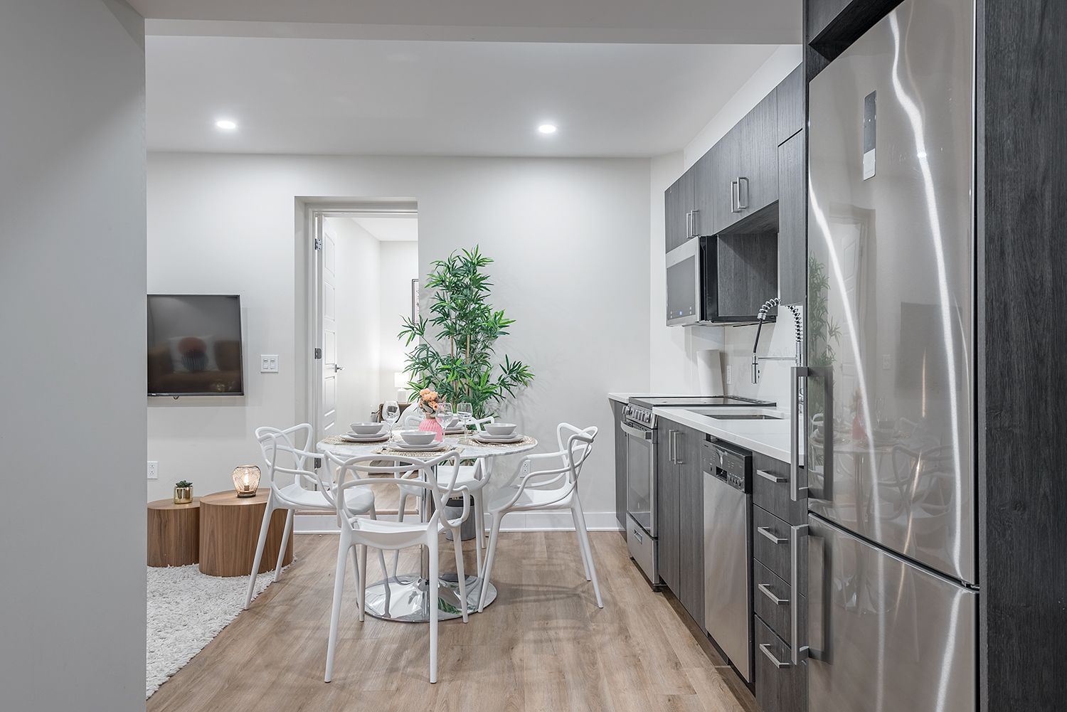 Cuisine et salle à manger modernes avec appareils en acier inoxydable et table ronde.
