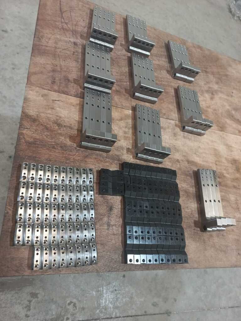 Una mesa de madera rematada con un montón de piezas de metal.