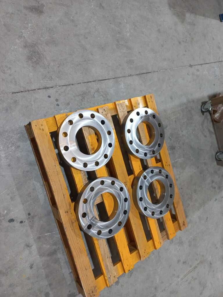 Una paleta de madera con cuatro anillos de metal sobre ella.