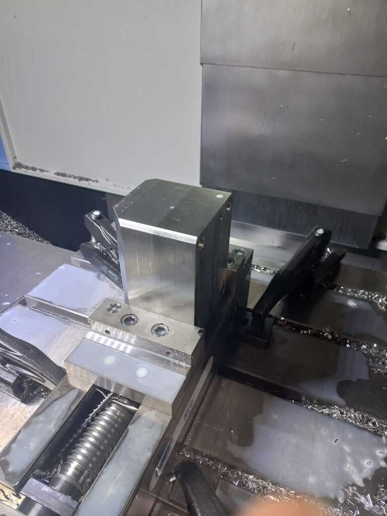 Una máquina está cortando un trozo de metal sobre una mesa.