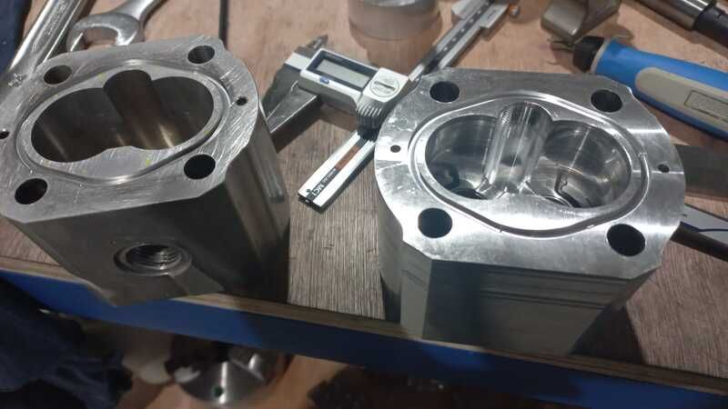 Dos cilindros de metal están sobre una mesa de madera al lado de un calibrador digital.