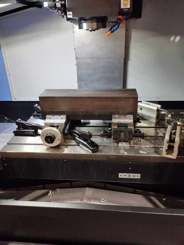 Una máquina está cortando un trozo de metal sobre una mesa.