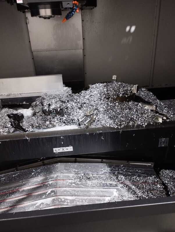 Una máquina está cortando un trozo de metal sobre una mesa.