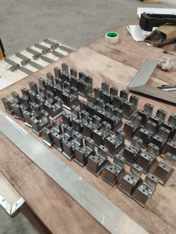 Una mesa de madera con muchas piezas de metal sobre ella.