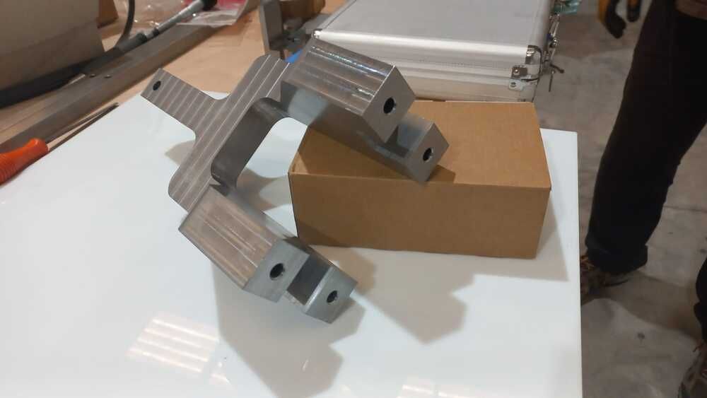 Un trozo de metal está encima de una caja de cartón sobre una mesa.