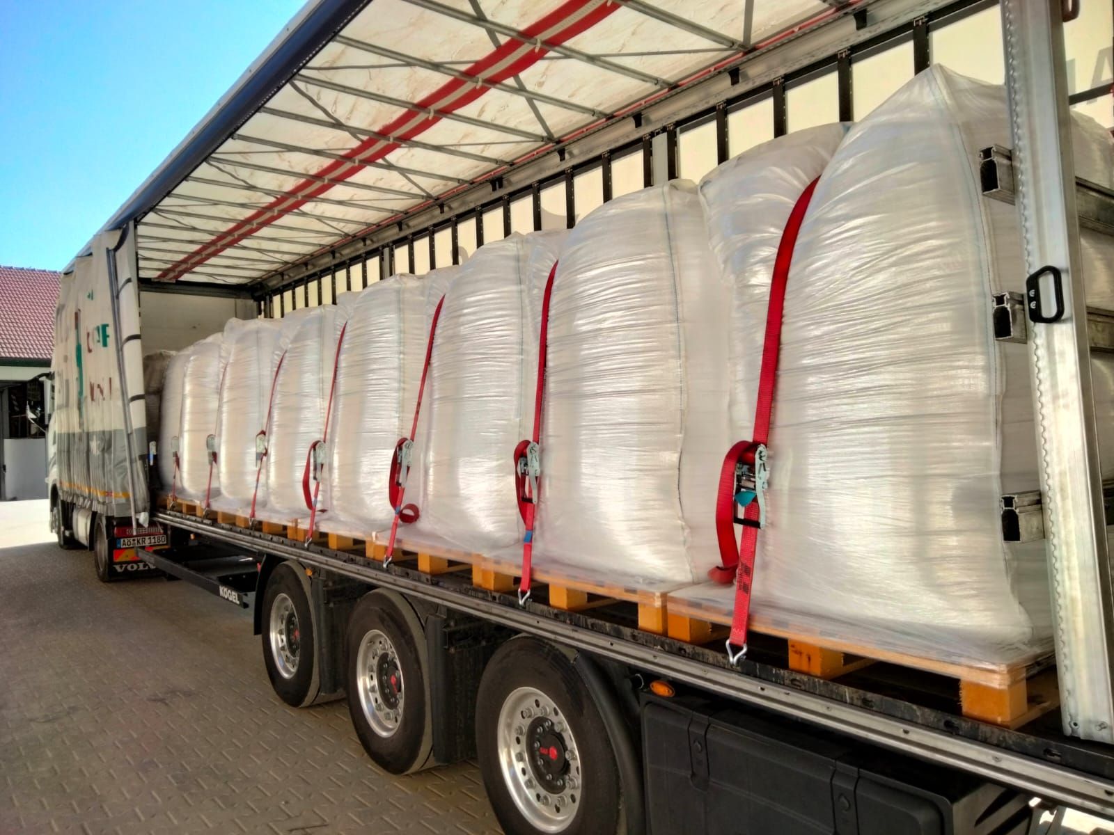 Ein LKW ist mit vielen Säcken auf einer Holzpalette beladen.