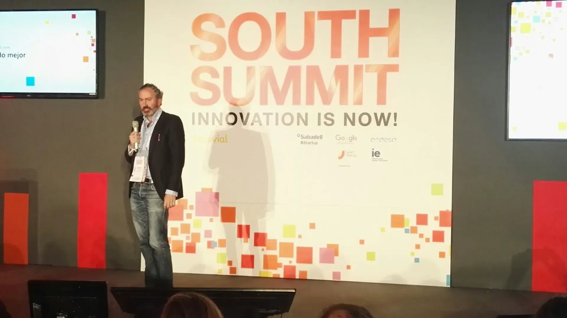 Un hombre está dando un discurso en la cumbre del sur. La innovación es ahora.