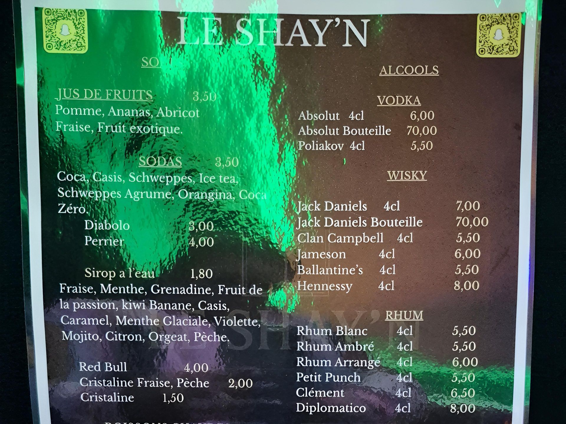 Carte du bar proposant des jus de fruits, des sodas, des sirops et des boissons alcoolisées comme la vodka, le whisky et le rhum.