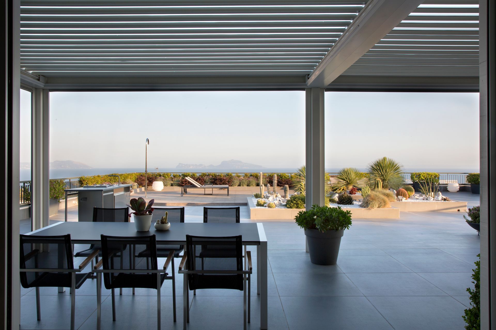 Espace repas extérieur avec table et chaises, donnant sur un paysage pittoresque.