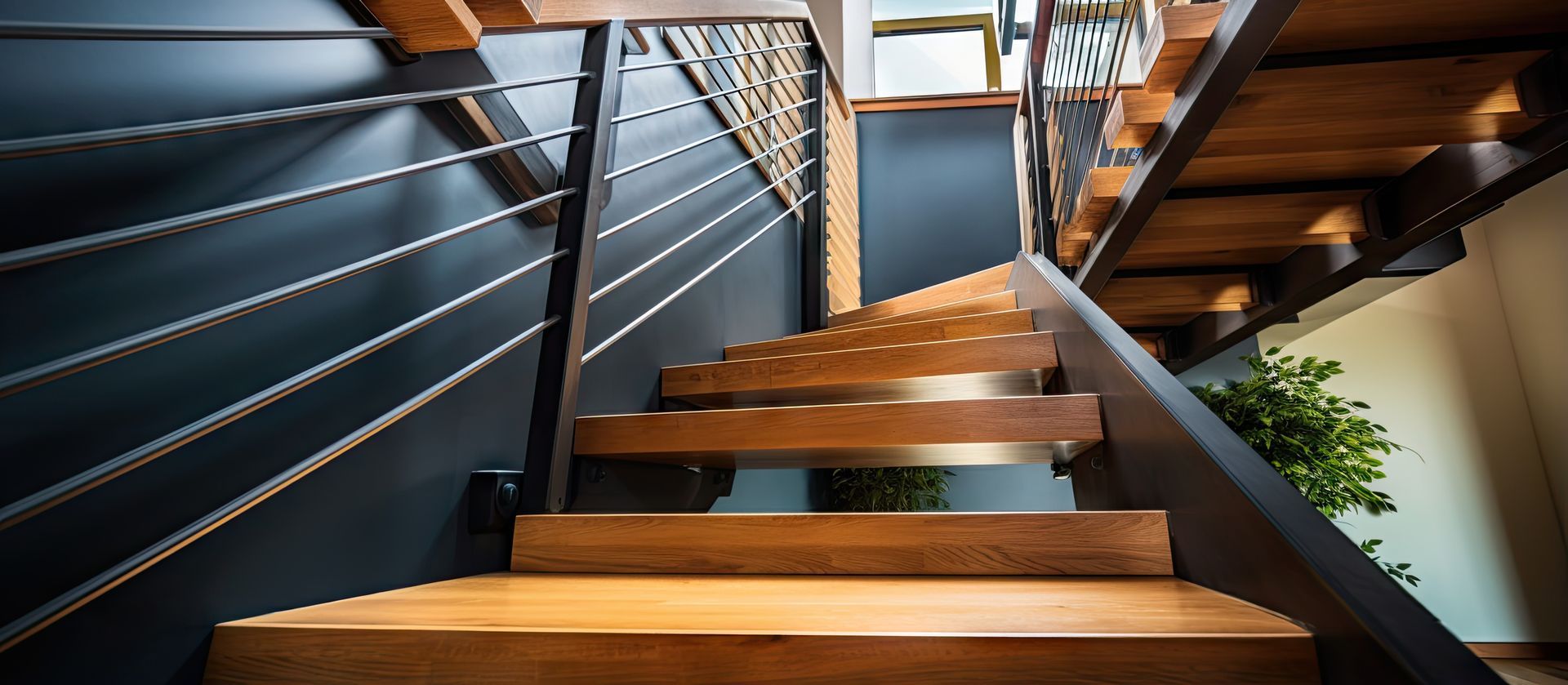 Escalier en bois avec rampes en métal noir, la lumière du soleil projetant des ombres.