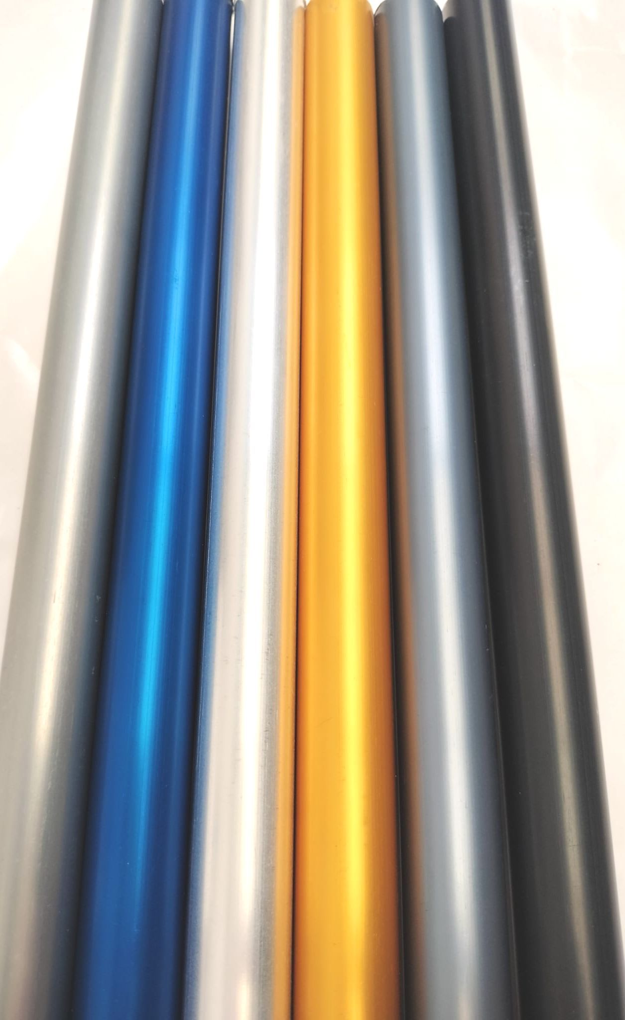 Un montón de tubos metálicos de diferentes colores se apilan uno encima del otro.