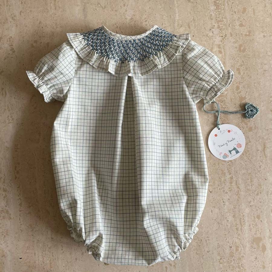 Pelele de bebé con cuello fruncido de color azul y estampado de cuadros.