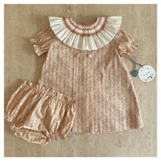 Conjunto de vestido y pantalón bombacho para niña, estampado floral en tonos crema y rojo, con cuello con volante.