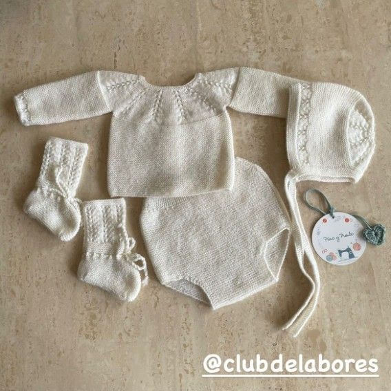 Conjunto de bebé de punto en color crema: jersey, pantalón bombacho, gorrito y calcetines.