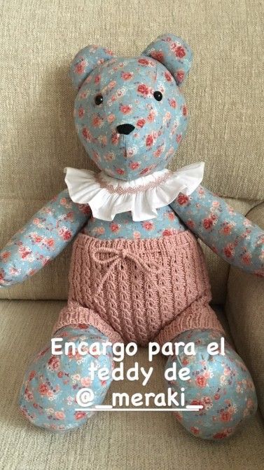 Osito de peluche de tela floral con pantalón corto de punto rosa y cuello con volantes.