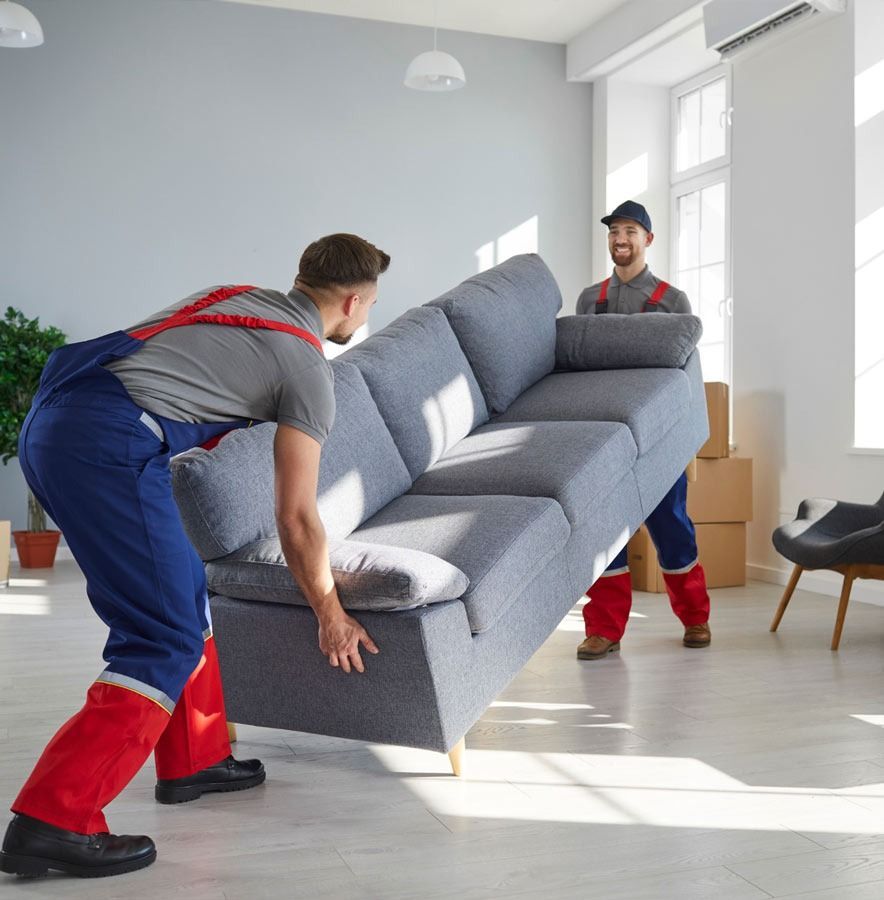 Dos hombres están moviendo un sofá en una sala de estar.