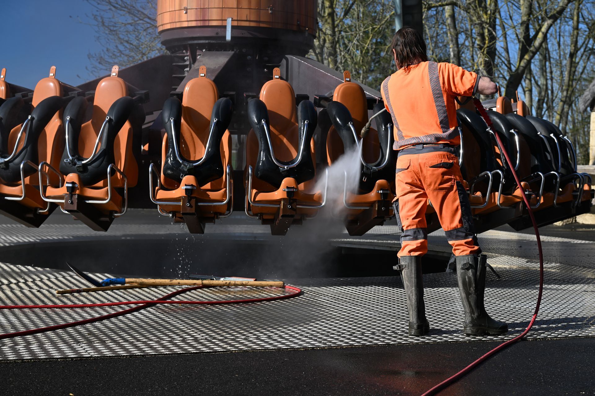 Ouvrier vêtu d’une tenue de haute visibilité utilisant un nettoyeur à haute pression
