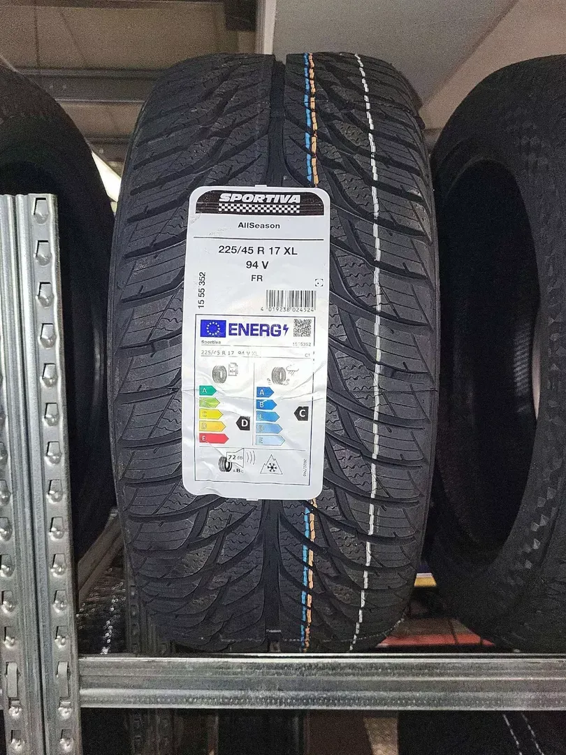 Ein neuer schwarzer Autoreifen im Regal, mit einem Aufkleber, der seine Energieeffizienzklasse angibt.