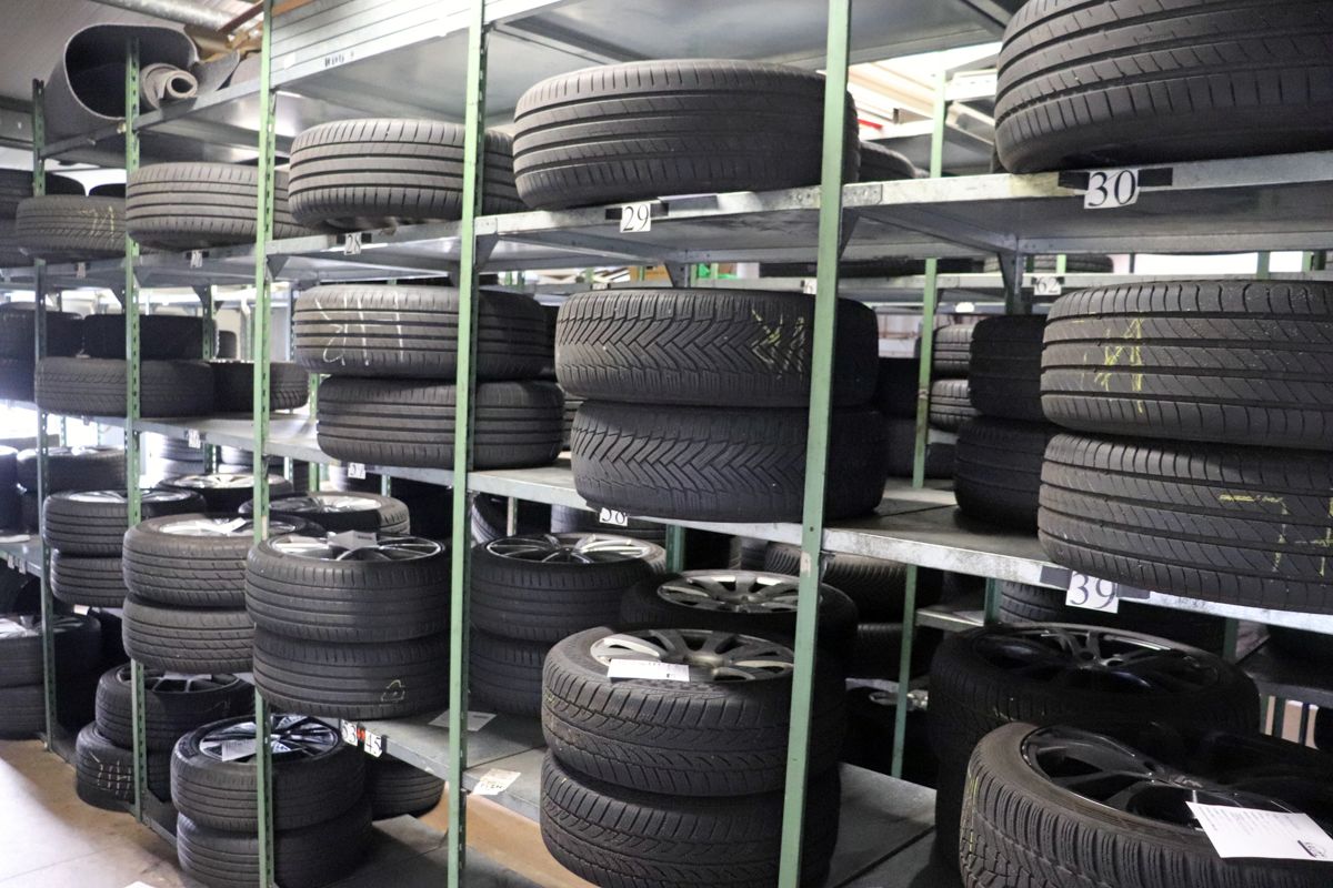 Reifen, gestapelt auf Metallregalen in einem Lagerraum.