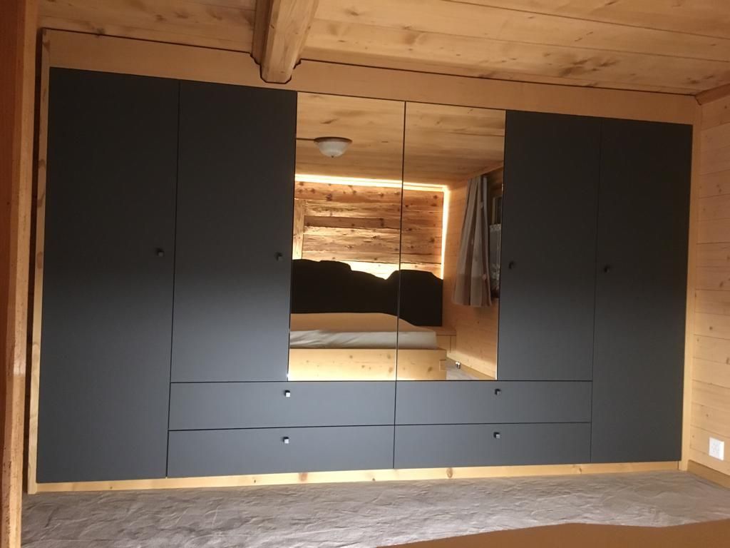 Ein Schlafzimmer mit großem Kleiderschrank und großem Spiegel