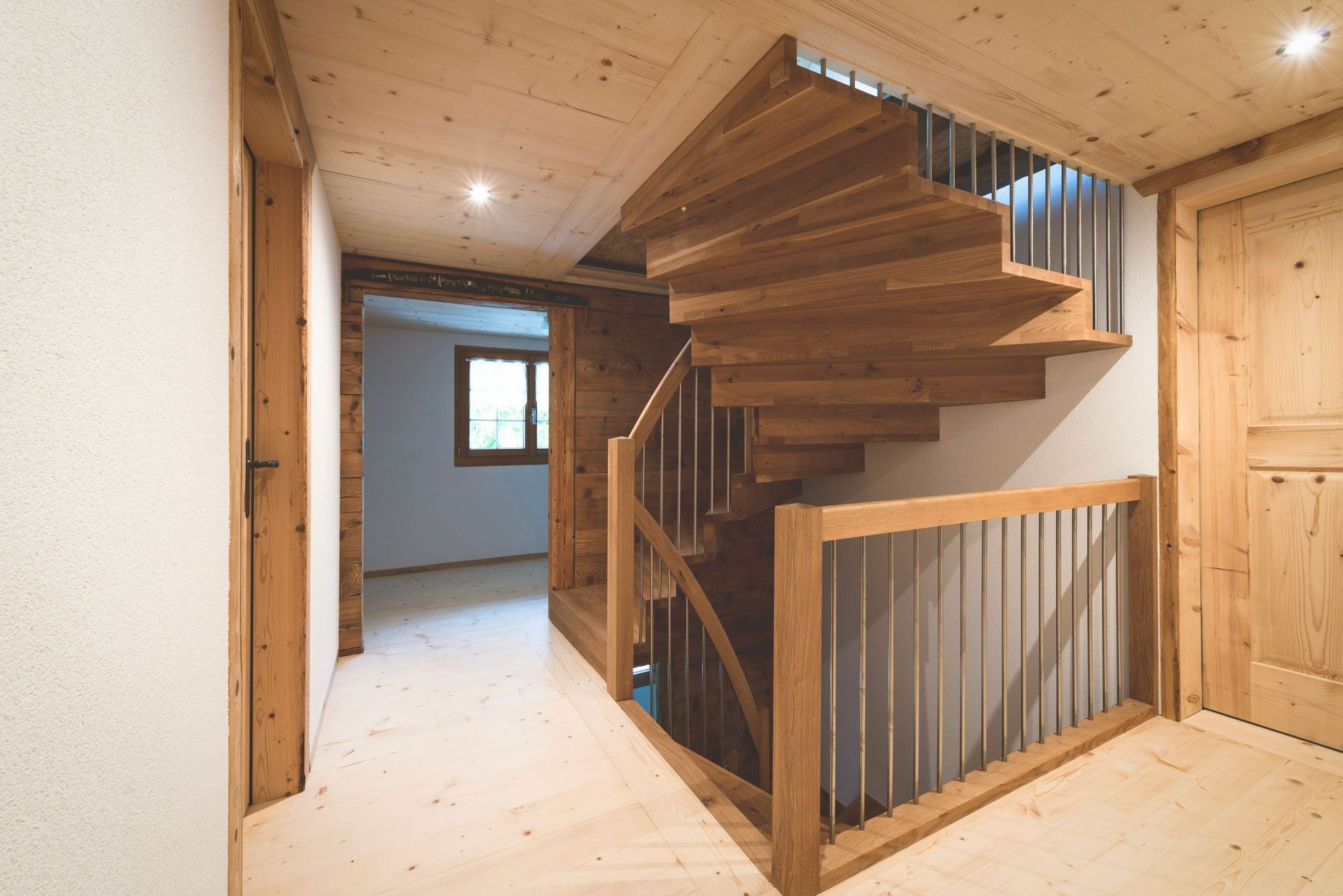 Eine hölzerne Wendeltreppe in einem Flur in einem Haus.