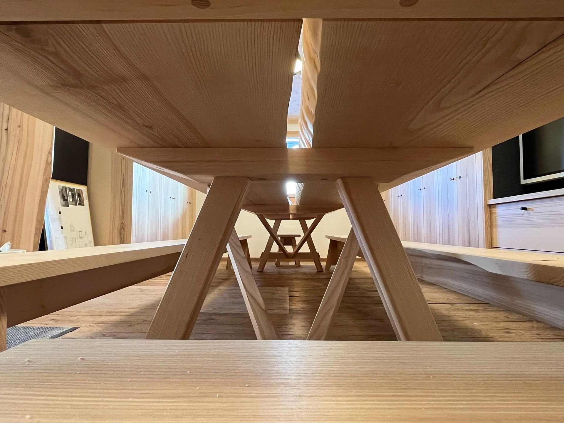 Ein Holztisch mit Bänken darunter in einem Raum.