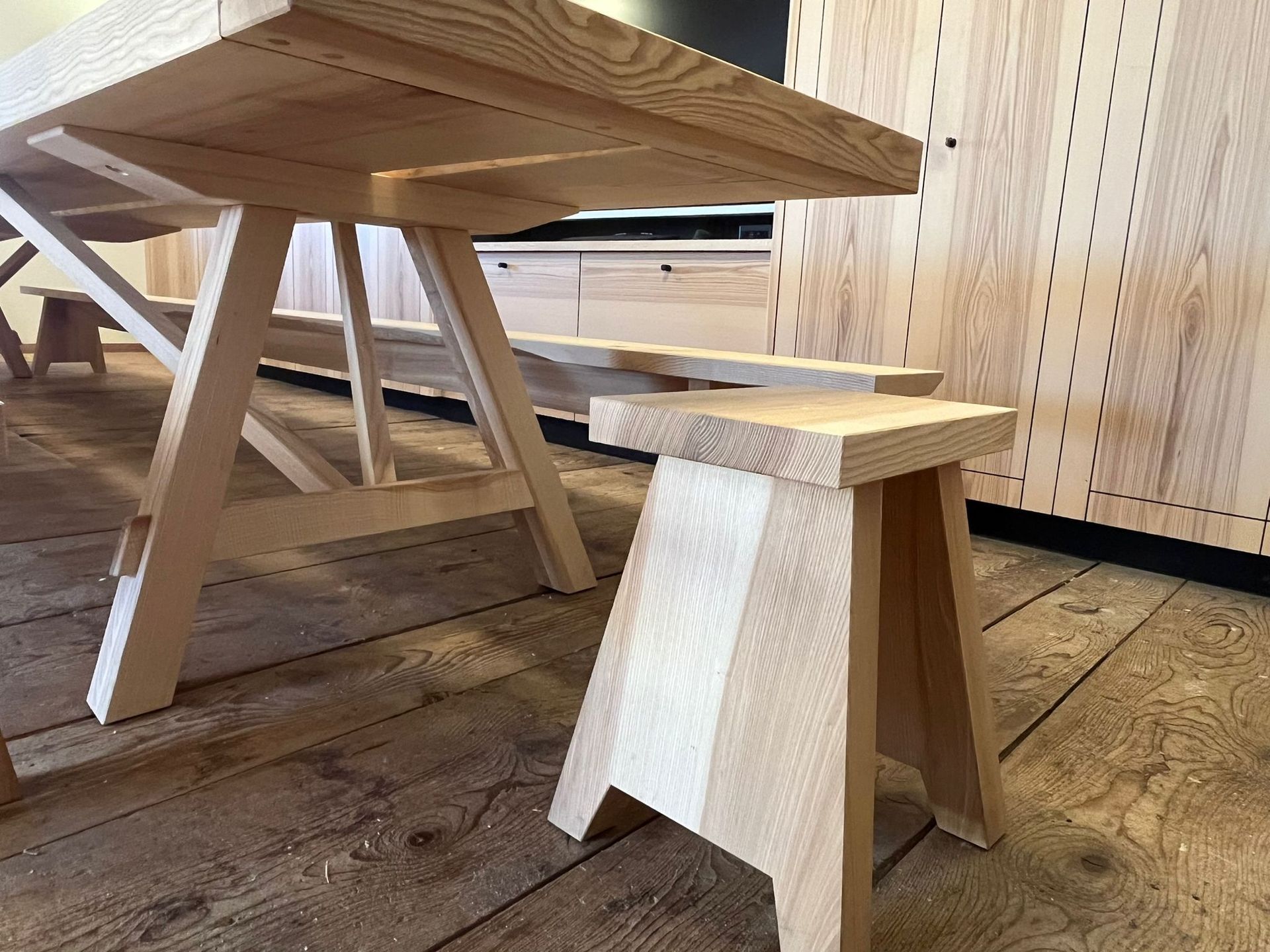 Ein Holztisch und eine Bank stehen auf einem Holzboden.