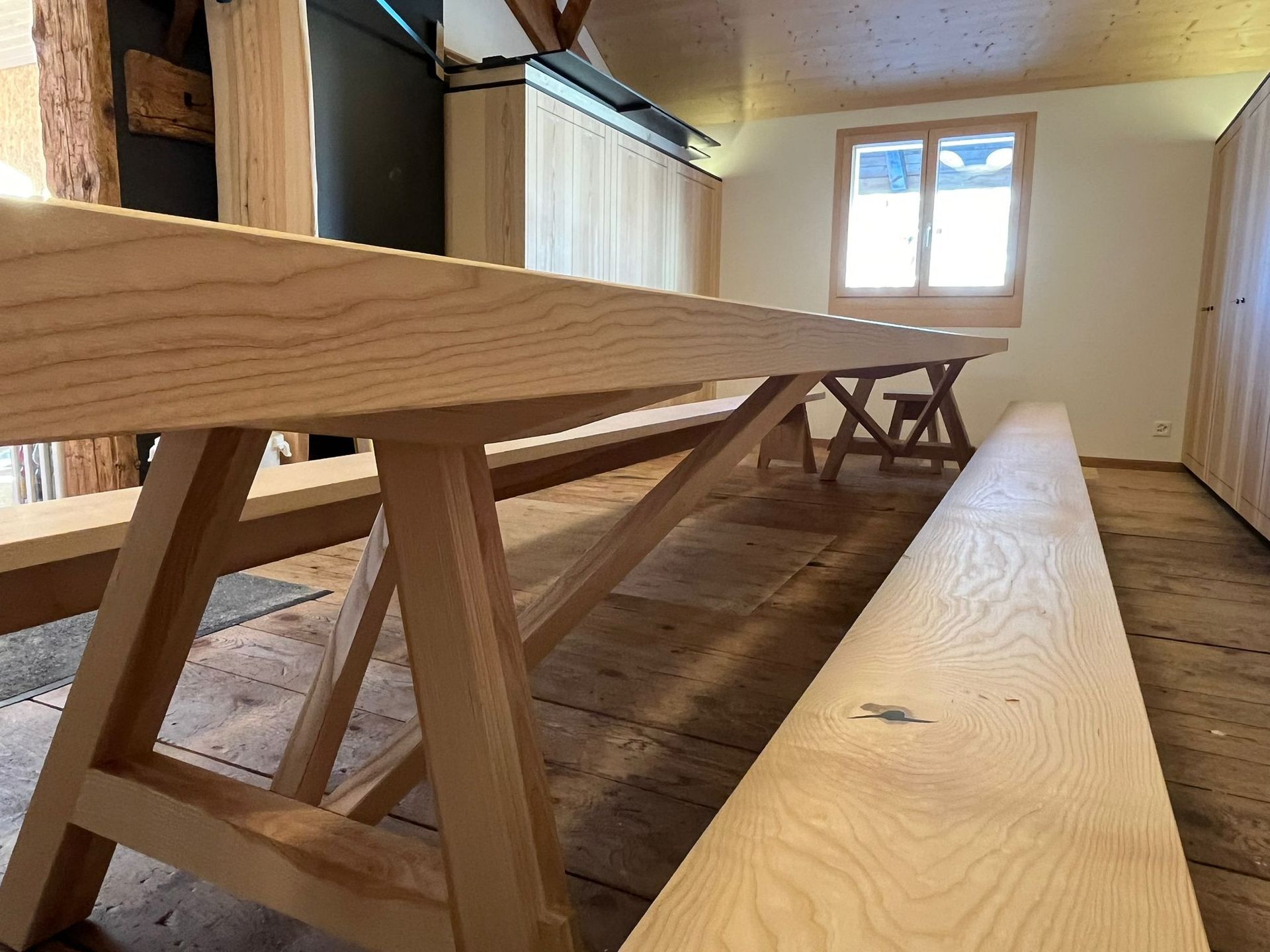 Ein Holztisch und Bänke in einem Raum mit einem Fenster