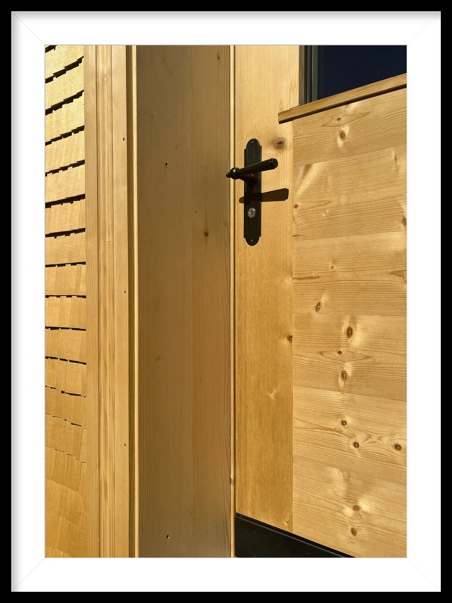 Ein Bild einer Holztür mit einem schwarzen Griff