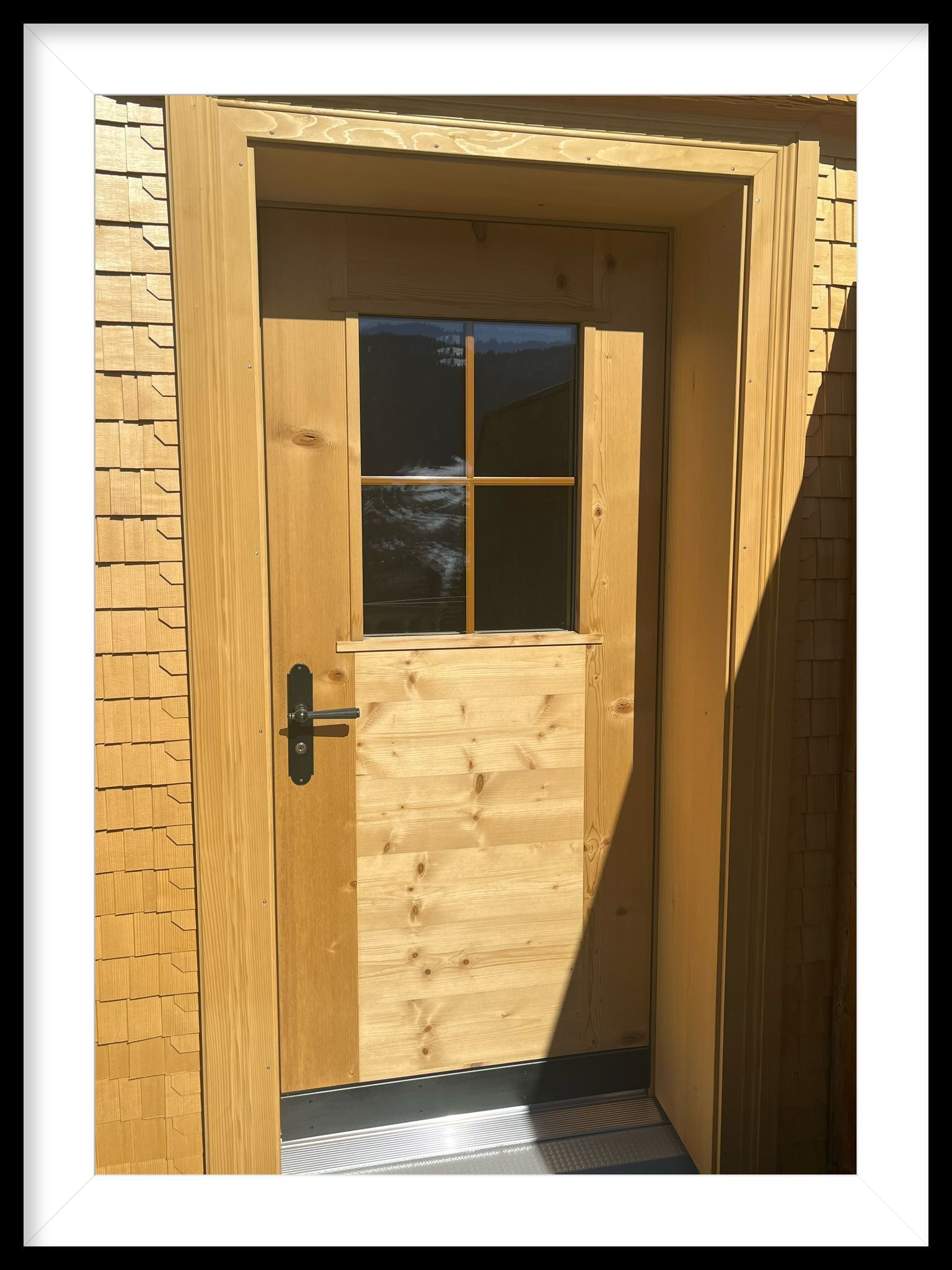 Ein Bild einer Holztür mit einem schwarzen Griff