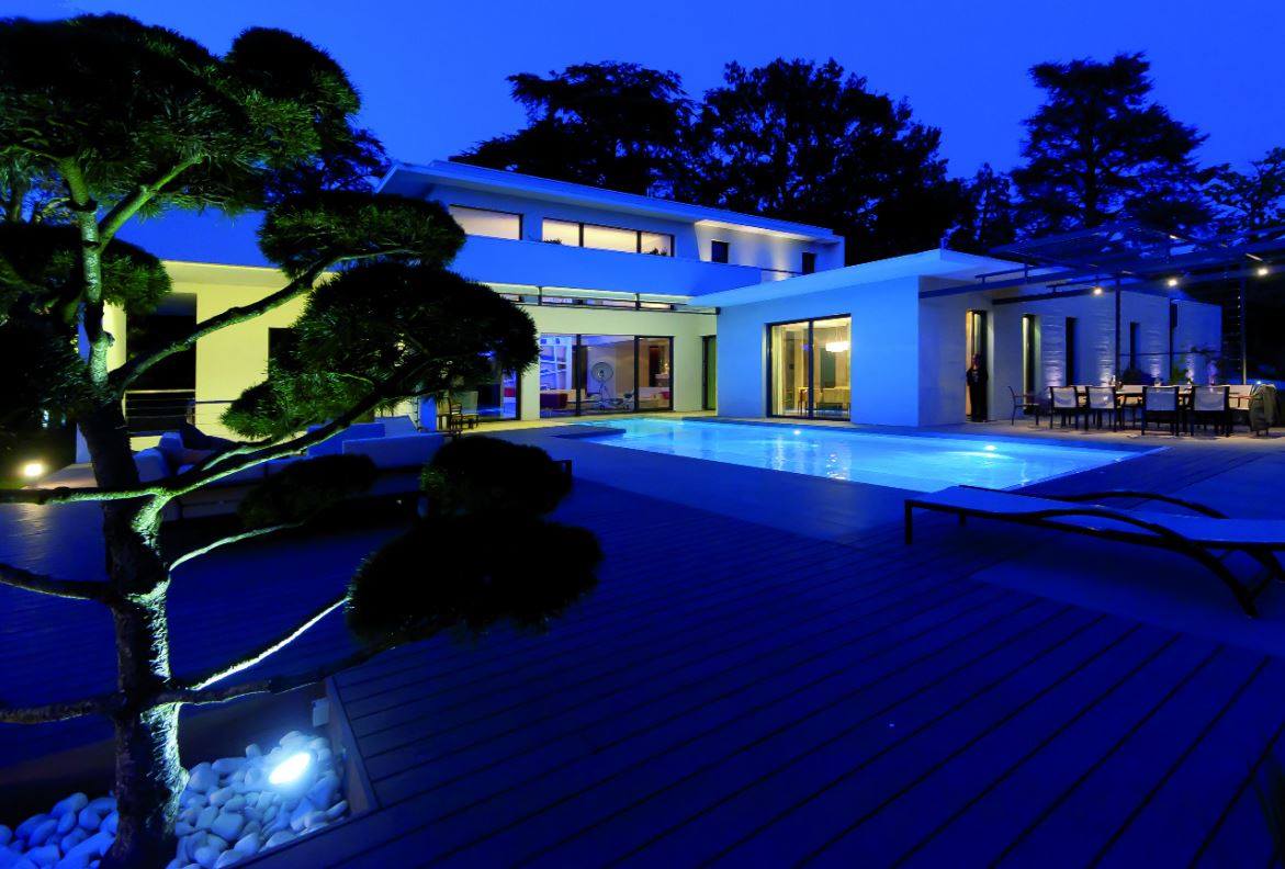 Éclairage d'une villa avec un arbre au premier plan