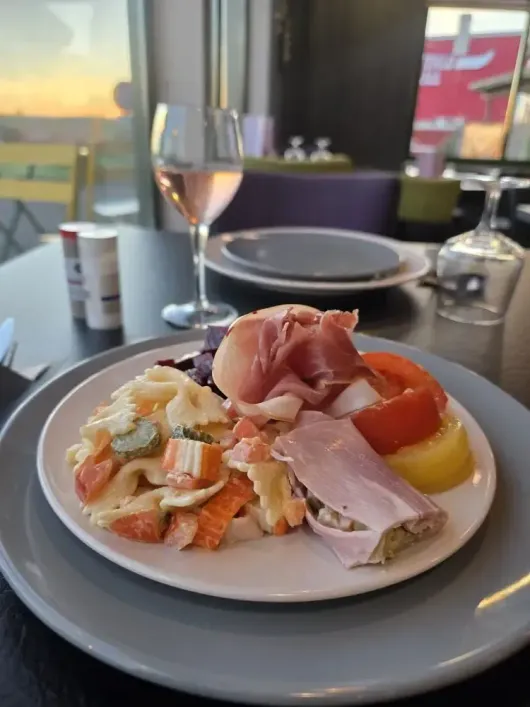 Buffet avec divers plats : pâtes, salades, fritures et fruits.