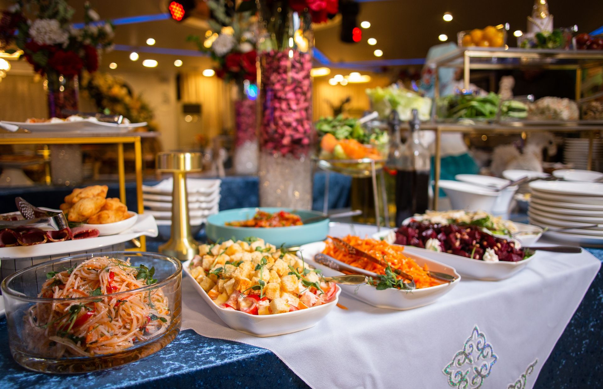 Buffet avec divers plats : pâtes, salades, fritures et fruits.