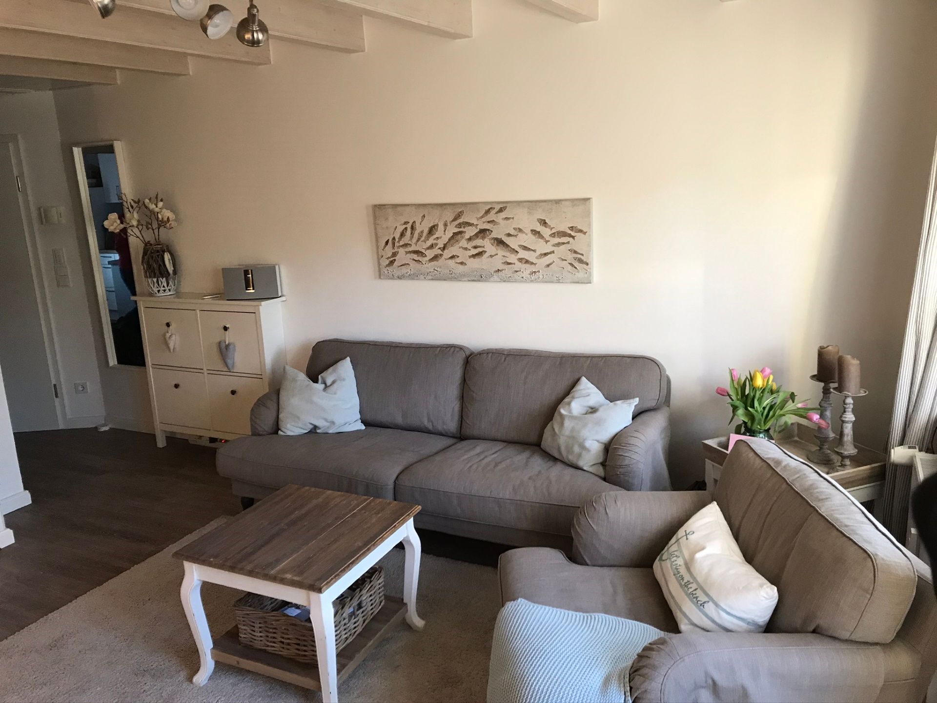 Wohnzimmer mit großen Sofa, Tisch und Bose Soundsystem