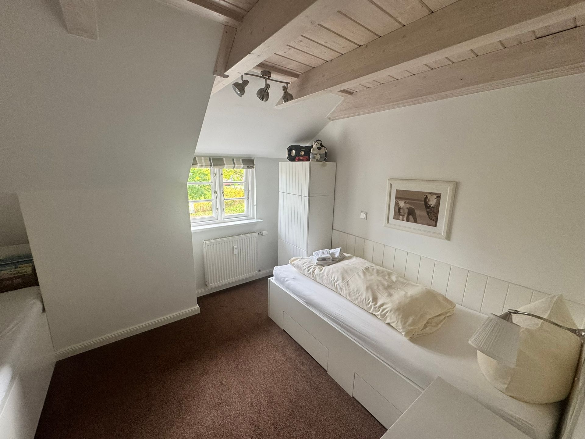 Schlafzimmer 2 mit 2 Einzelbetten, Wäscheschubladen in den Betten und kleinem Kleiderschrank.