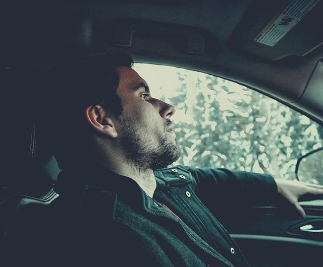 Un hombre conduce un coche con los ojos cerrados.