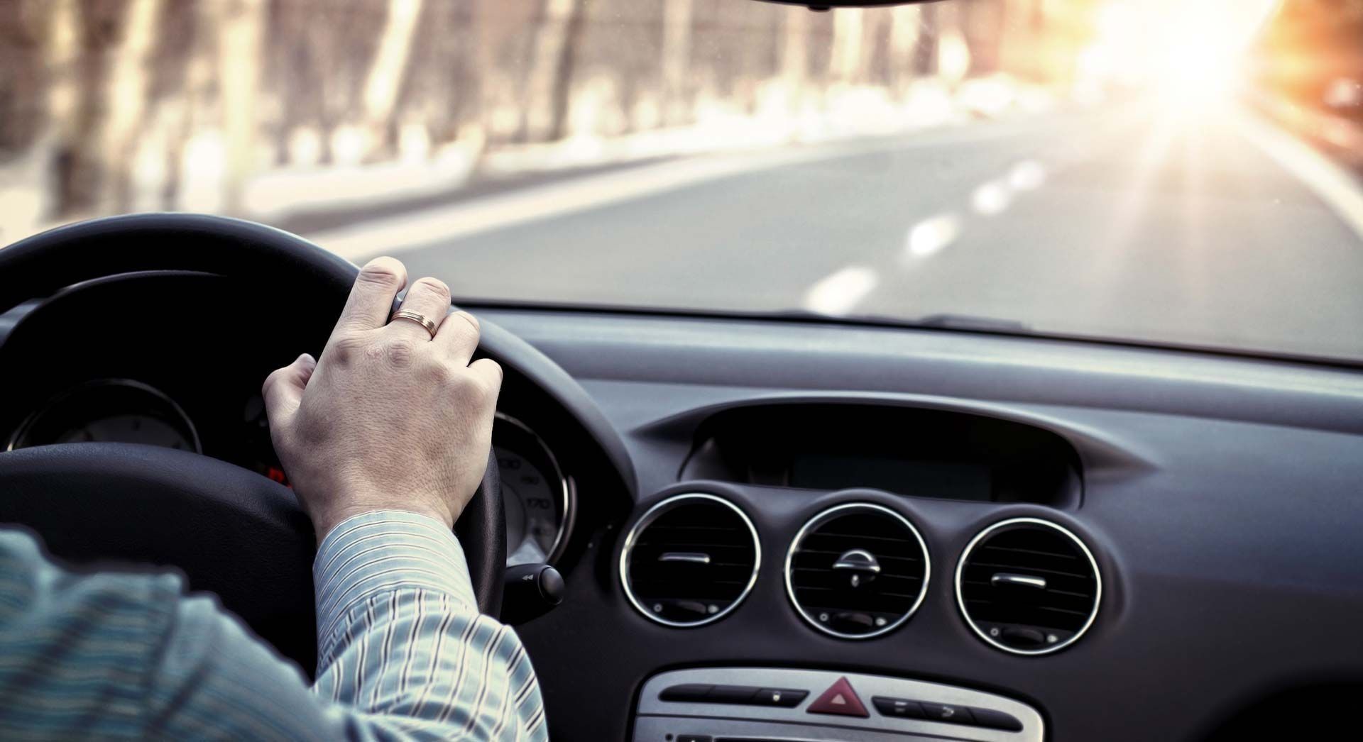 Un hombre conduce un coche por una autopista.