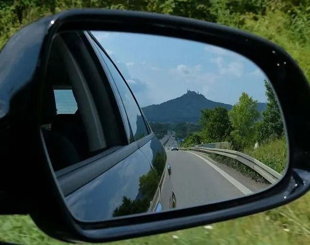 Un coche circula por una autopista con una montaña al fondo.
