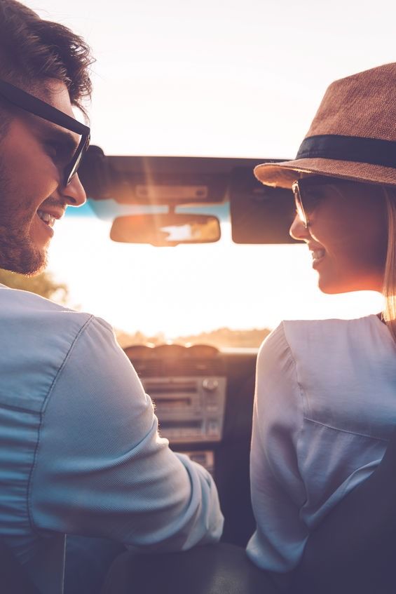 Un hombre y una mujer se miran en un coche.