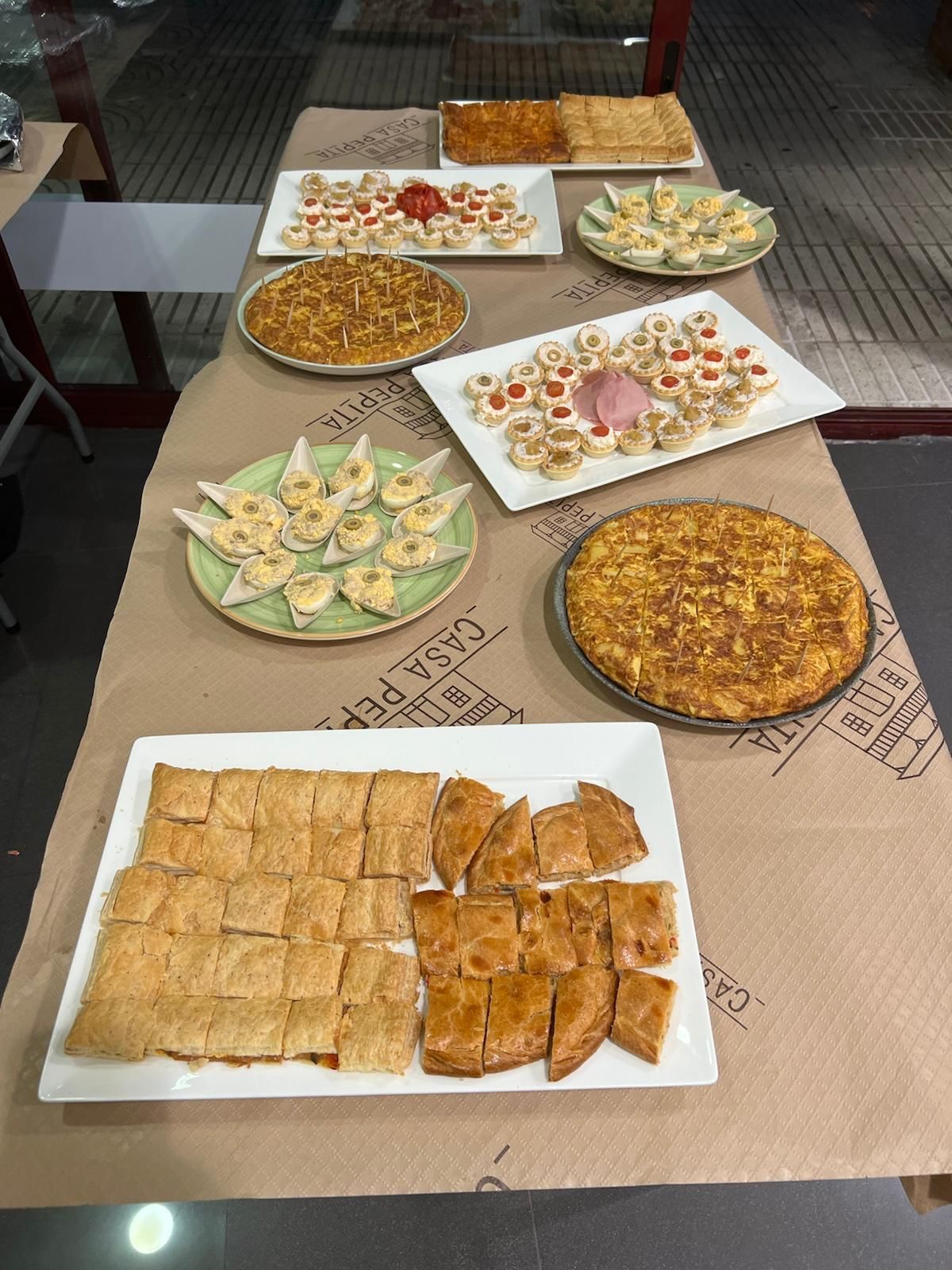 Una mesa cubierta con platos de comida, incluida una pizza.