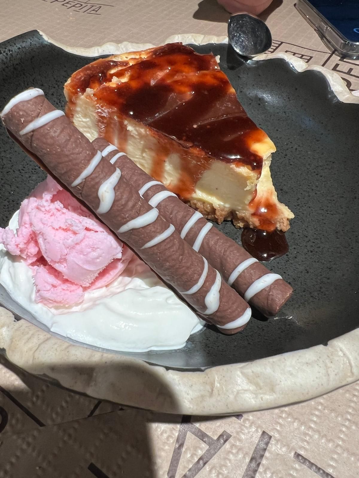 Una rebanada de tarta de queso con helado y galletas de chocolate en un plato