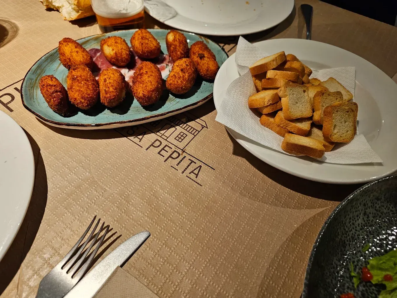 Una mesa con platos de comida y una servilleta que dice pepita