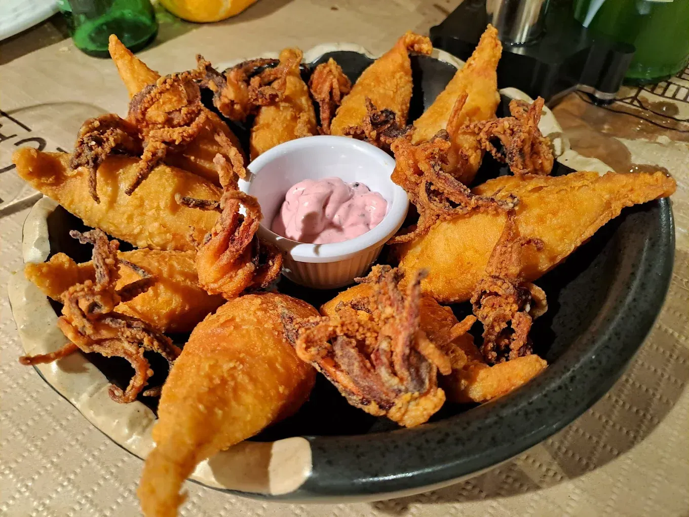 Un plato de pulpo frito con salsa para mojar