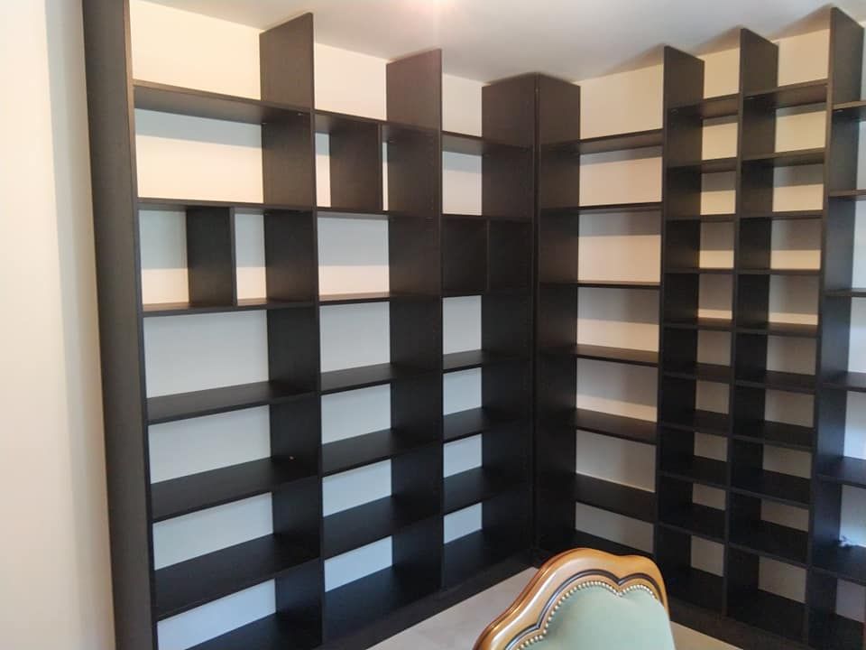 Photo qui représente un dressing avec une penderie remplie de vêtements