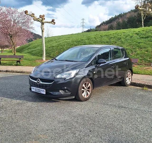 Un coche negro está estacionado al costado de la carretera.