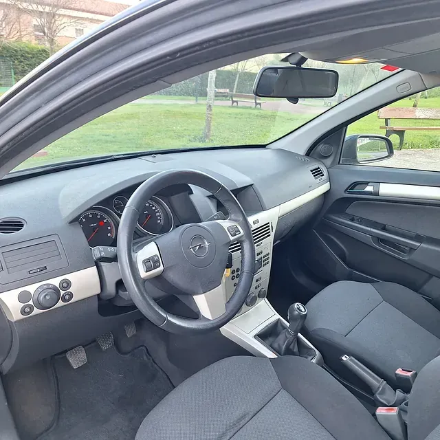 The inside of a car with a steering wheel and seats