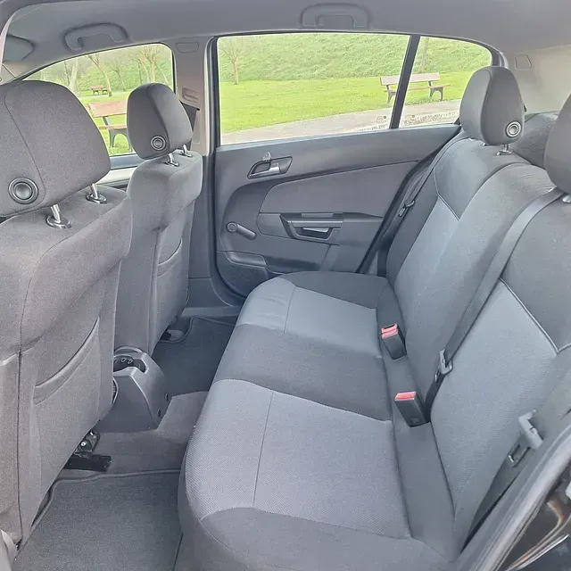The back seat of a black car with gray seats